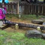 child playing in water sluiceway in an inclusive playground